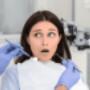 Feeling Nervous About Visiting Dentist - a nervous female patient looking at dentist before treatment Feeling Nervous About Visiting Dentist - a nervous female patient looking at dentist before treatment