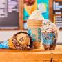 Waffle cone, shake and sundae in front of Ben & Jerry's ice cream shop menu board. Waffle cone, shake and sundae in front of Ben & Jerry's ice cream shop menu board.