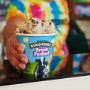 Scooper handing a fresh packed pint over the counter at a Ben & Jerry's ice cream shop. Scooper handing a fresh packed pint over the counter at a Ben & Jerry's ice cream shop.