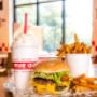 A Five Guys cheeseburger, milkshake and regular order of fries sits on a table inside a Five Guys restaurant. A Five Guys cheeseburger, milkshake and regular order of fries sits on a table inside a Five Guys restaurant.