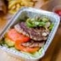 A photograph of the contents of a Five Guys burger bowl, which include two ground beef patties, tomatoes, jalapenos, lettuce and pickles. A photograph of the contents of a Five Guys burger bowl, which include two ground beef patties, tomatoes, jalapenos, lettuce and pickles.