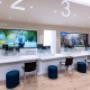 Modern office or service area at AMA Centre in Westbrook Mall, Calgary, featuring four numbered counters. Background includes large digital screens displaying various images. Modern office or service area at AMA Centre in Westbrook Mall, Calgary, featuring four numbered counters. Background includes large digital screens displaying various images.