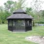 Gazebo Québec - Modèle Le Mont-Tremblant - 6 Cotés - 14' de diamètre - Gazebo de couleur noir entouré de gazon. Toiture double avec bardeaux noir 2 tons Gazebo Québec - Modèle Le Mont-Tremblant - 6 Cotés - 14' de diamètre - Gazebo de couleur noir entouré de gazon. Toiture double avec bardeaux noir 2 tons