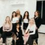 Friendly, professional hair stylists and nail technicians pose together in the modern, chic salon Friendly, professional hair stylists and nail technicians pose together in the modern, chic salon