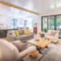 This residence is nestled in the woods and the open concept living space combines warm earth tones with a two tone kitchen with gold accents This residence is nestled in the woods and the open concept living space combines warm earth tones with a two tone kitchen with gold accents