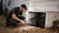 Seaside Pest Control Technician Inspecting Crawlspace for Spider Webs in Vancouver