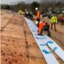 Crew members from AlphaNova Roofing installing underlayment on a commercial roofing project. Crew members from AlphaNova Roofing installing underlayment on a commercial roofing project.